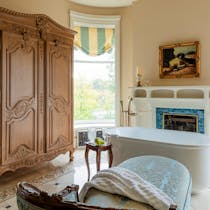 A new bathroom suite has modern, spa-like features such as an oval pillbox-shape tub while evoking vintage glam.