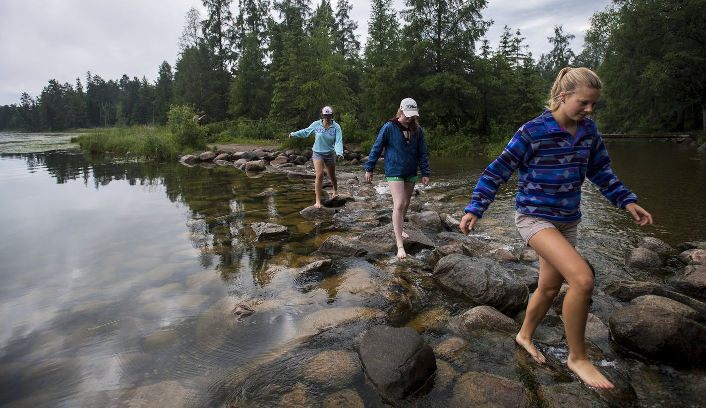 Emma Daniels, right, Abby MacFarlane and Marie Preston, back, walked across the rocks at the headwaters of the Mississippi at Lake Itasca in mid June. The high school seniors were visiting from Fergus Falls. ] (AARON LAVINSKY/STAR TRIBUNE) aaron.lavinsky@startribune.com RIVERS PROJECT: We look at three of Minnesota's rivers, including the Mississippi, Red and Chippewa, to see how land use effects water quality and pollution.