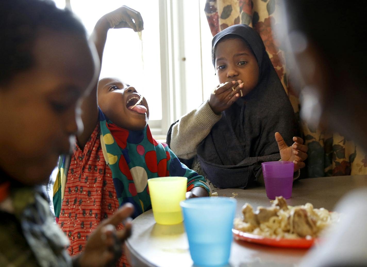 Recent Somali immigrants Hafifa Shukri, left, 4, and her sister Ugbad Shukri, 9, enjoy an afternoon snack of pasta with goat meat at home at Mary's Place transitional apartments in downtown Minneapolis. ] LEILA NAVIDI leila.navidi@startribune.com / BACKGROUND INFORMATION: Tuesday, October 28, 2014. Minnesota has seen a marked uptick in new Somali refugee arrivals recently. The number of Somalis arriving directly from Africa has more than tripled in four years. But community leaders say there's a