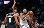 Brooklyn's Spencer Dinwiddie and Jarrett Allen, center, defend against Timberwolves center Karl-Anthony Towns during the first half.