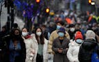 Shoppers wearing face masks walk down Oxford Street, Europe’s busiest shopping street, in London, Dec. 23. 