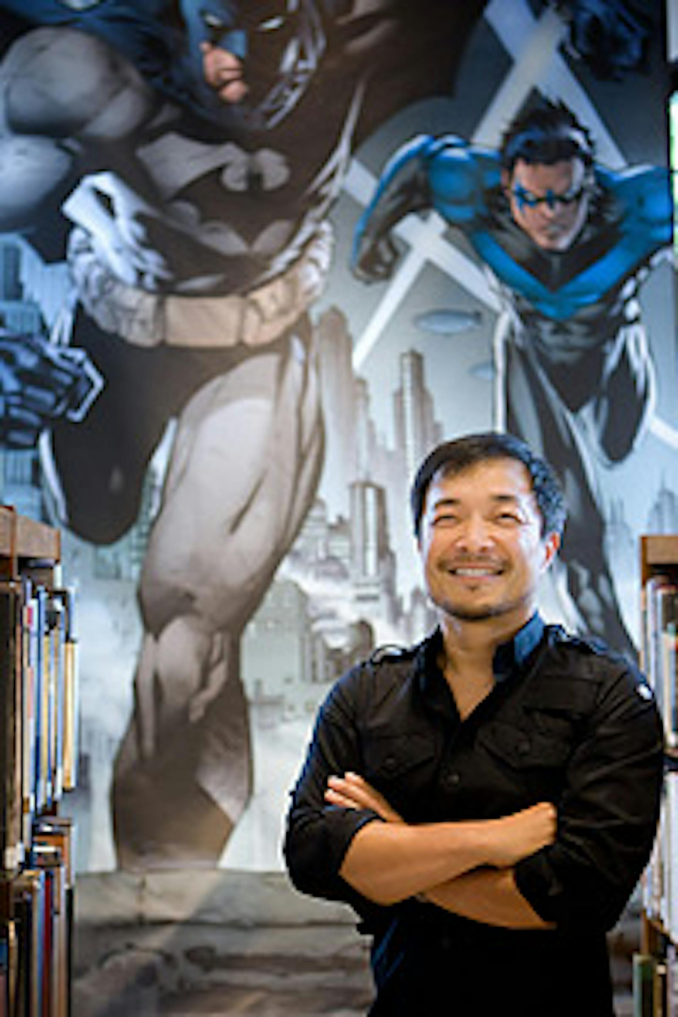 Jim Lee, with his artwork behind him.