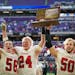 After defeating Fertile-Beltrami 58-8, LeRoy-Ostrander seniors Hayden Sass (58), Gavin Sweeney (24) and Tanner Olson (50) hold up the trophy for fans 