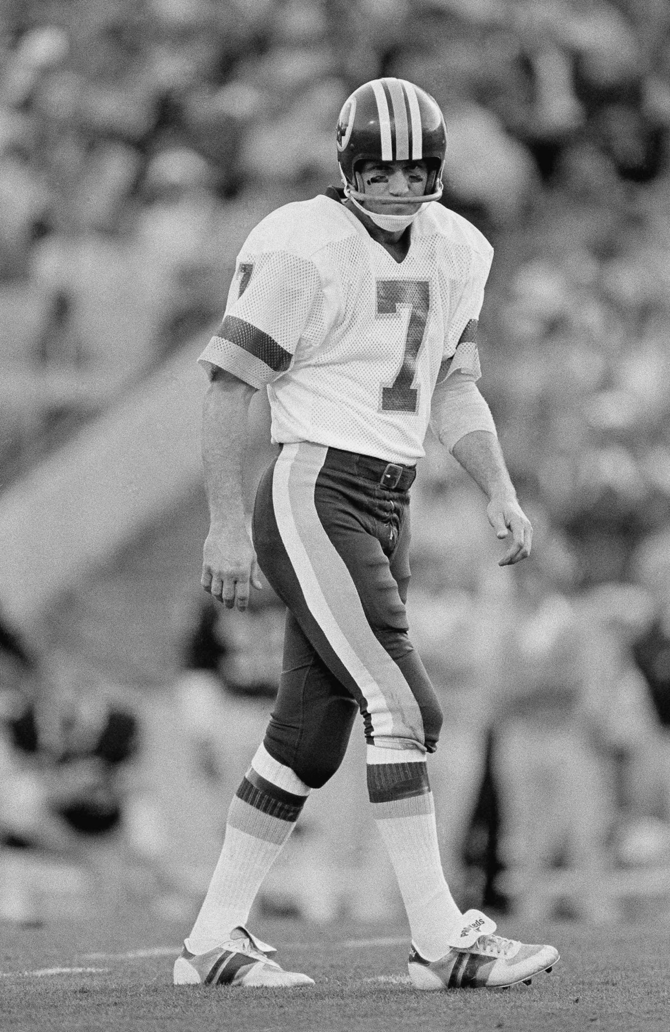 Washington Redskins quarterback Joe Theismann (7) wears a grim look as he walks of the field during first quarter Super Bowl XVIII action against the Los Angeles Raiders, Sunday, Jan. 22, 1984 at Tampa Stadium. (AP Photo) ORG XMIT: APHS179175