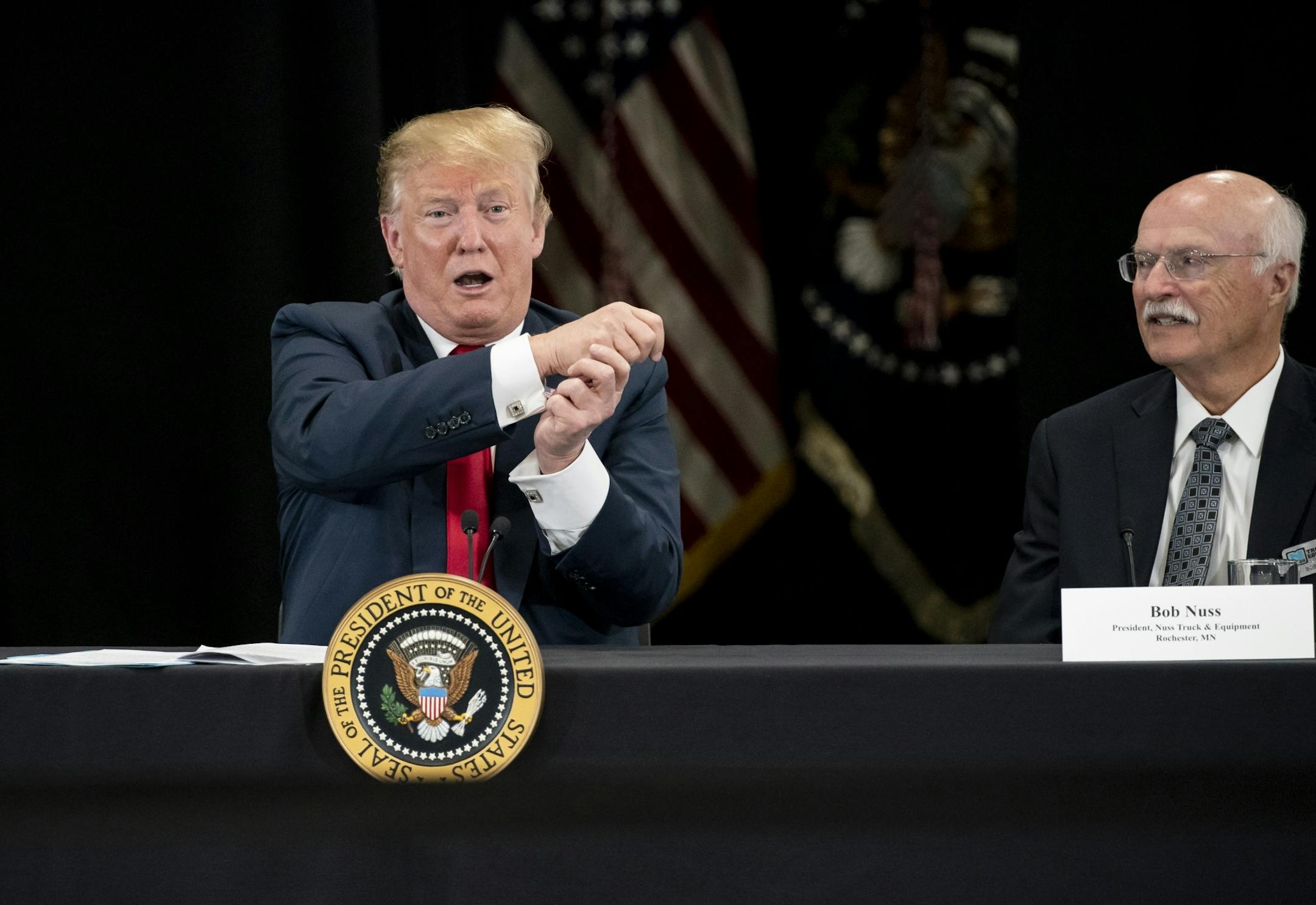 President Donald J. Trump pretended to wave a flag as he spoke at Nuss Truck and Equipment in Burnsville during a roundtable discussion on tax cuts and the U.S. economy in Burnsville, Minn., on Monday, April 15, 2019. At right is the president of Nuss Truck and Equipment Bob Nuss.