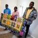 Refugees from Congo Sadock Ekyochi, from left, his wife Riziki Kashindi and her brother Kaaskile Kashindi pose for a photo inside their new apartment,