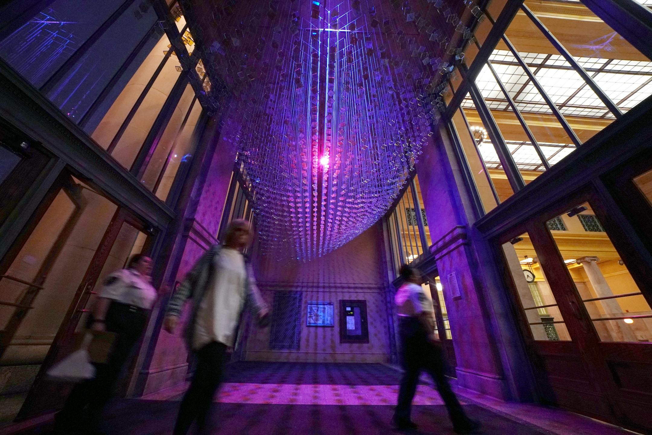 The artwork titled "Tin Waves" by Ray King uses glass and metal pieces hung from the ceiling in the entryway to Union Depot.