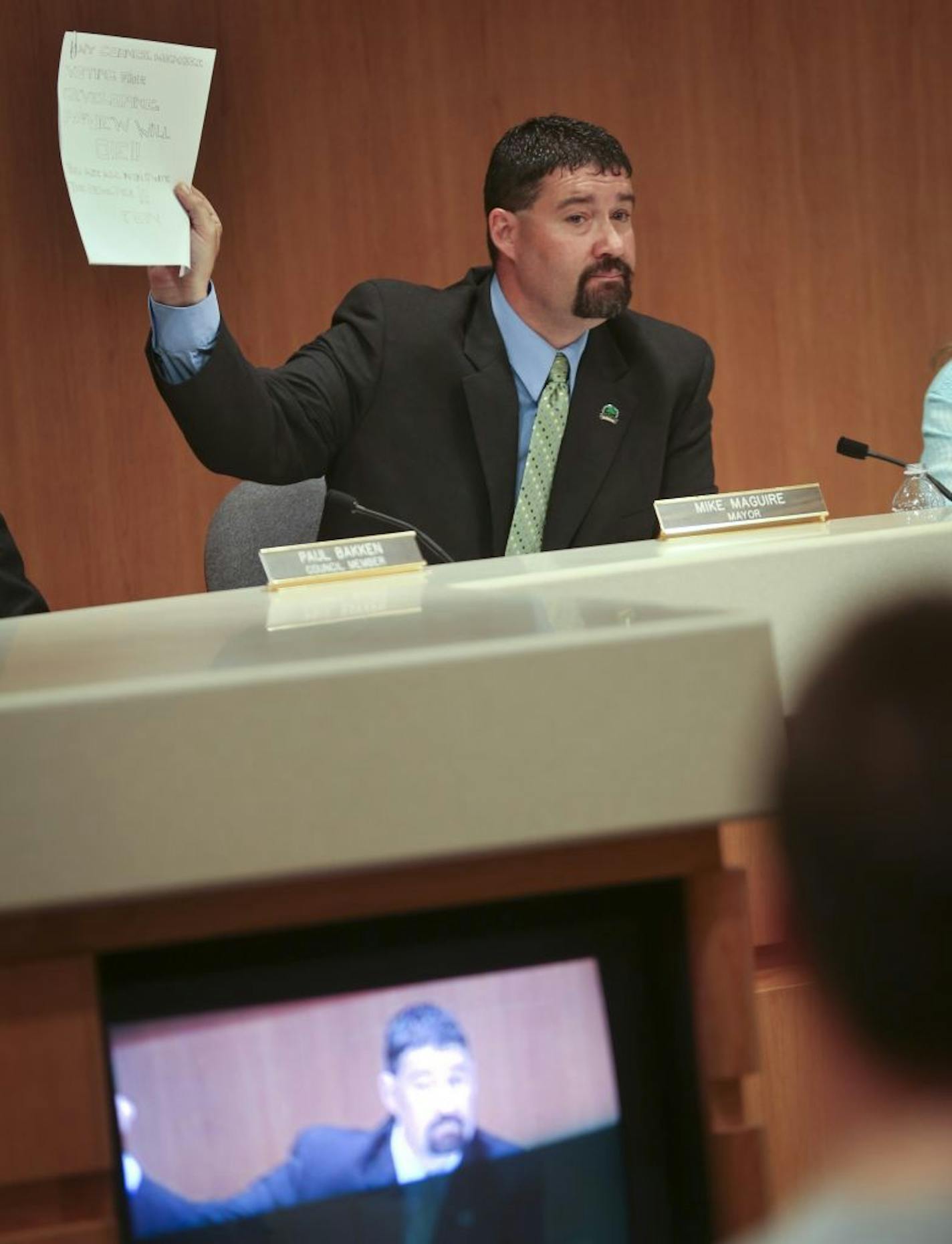 Eagan Mayor Mike Maguire held up a letter that threatened elected officials.