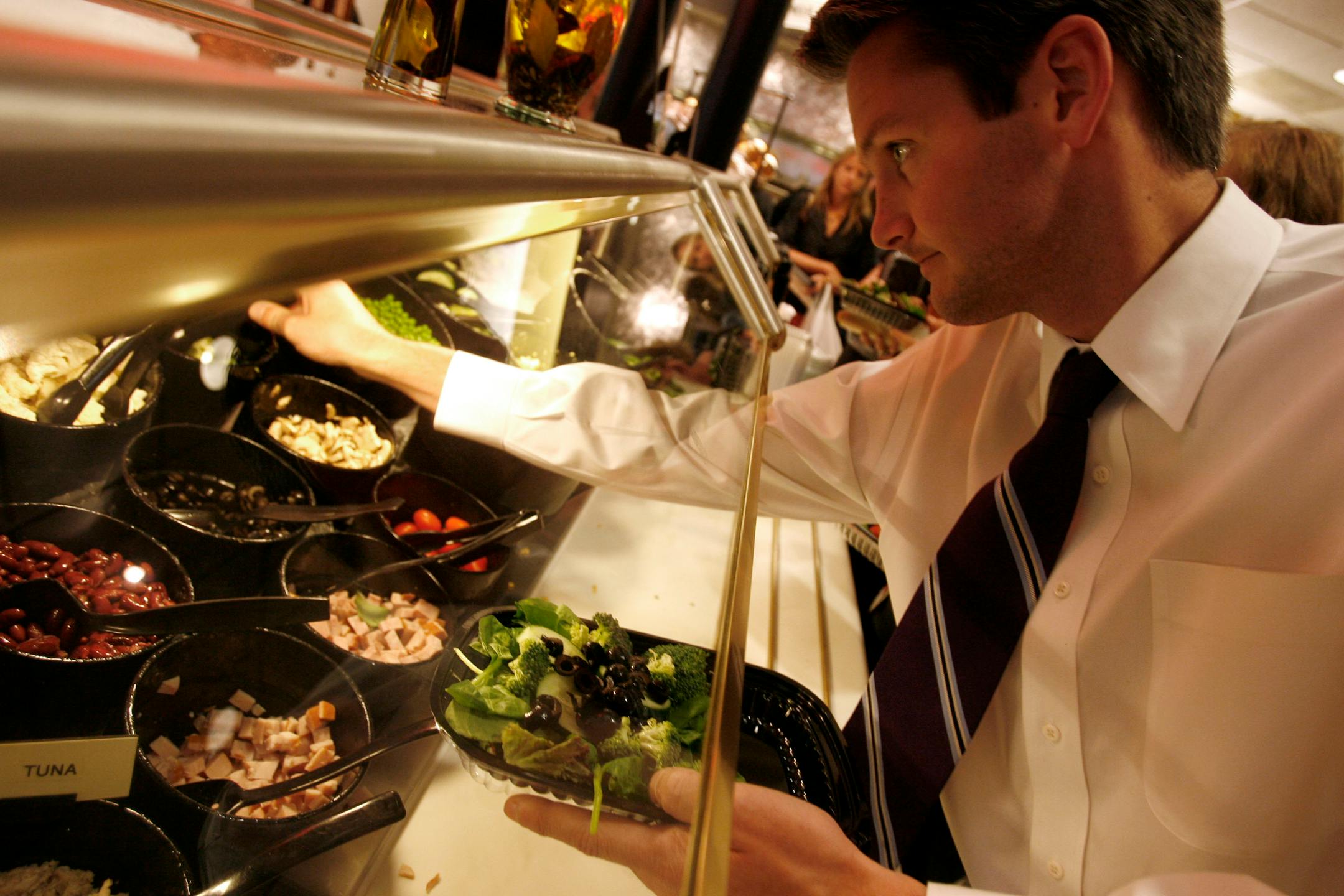 In a tight economy, more people are scaling back on lunches and bringing in their meals, and some are augmenting their brownbag lunches with salads or bread llike Josh Soldin, a Target human resources employee who made a salad at the Target Cafe in downtown Minneapolis. Soldin says he often brings a portion of his lunch from home and will purchase something to add to it in the cafe.