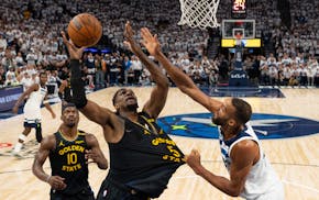 Warriors forward Kevon Looney (5) grabs an offensive rebound as Timberwolves center Rudy Gobert defends on Tuesday at Target Center.