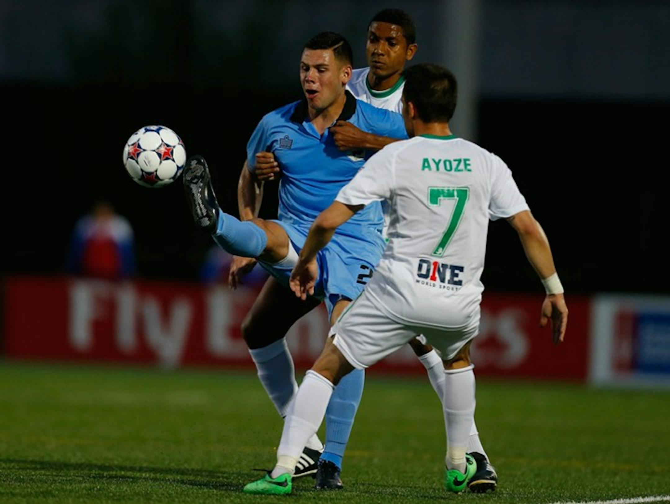 Christian Ramirez (in blue) is marked by New York's Ayoze Garcia Perez and another Cosmos player during Monday's game.