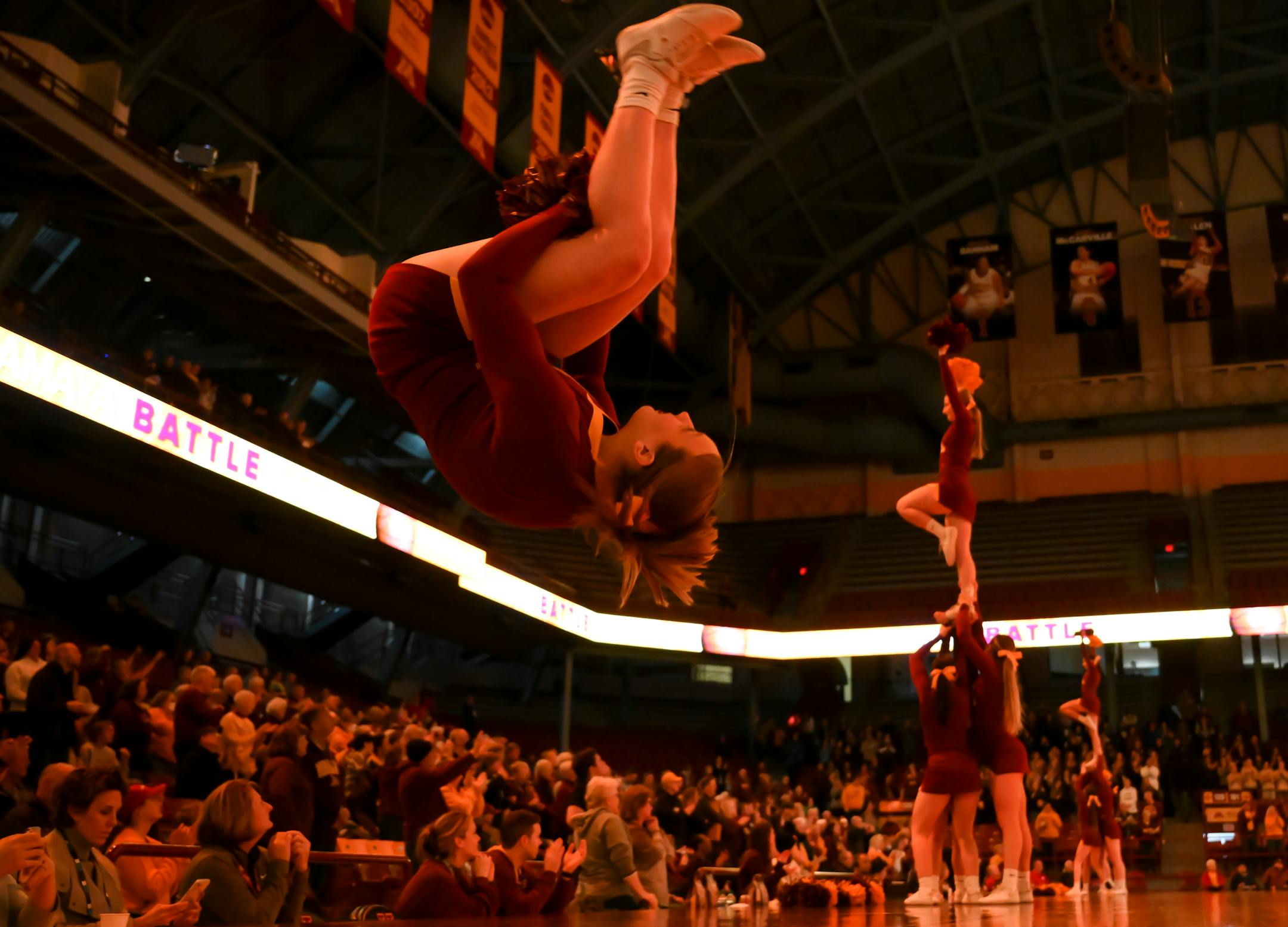 A cheerleader does a back flip during team introductions before the start of an NCAA women's basketball game between the Minnesota Golden Gophers and the Nebraska Cornhuskers.