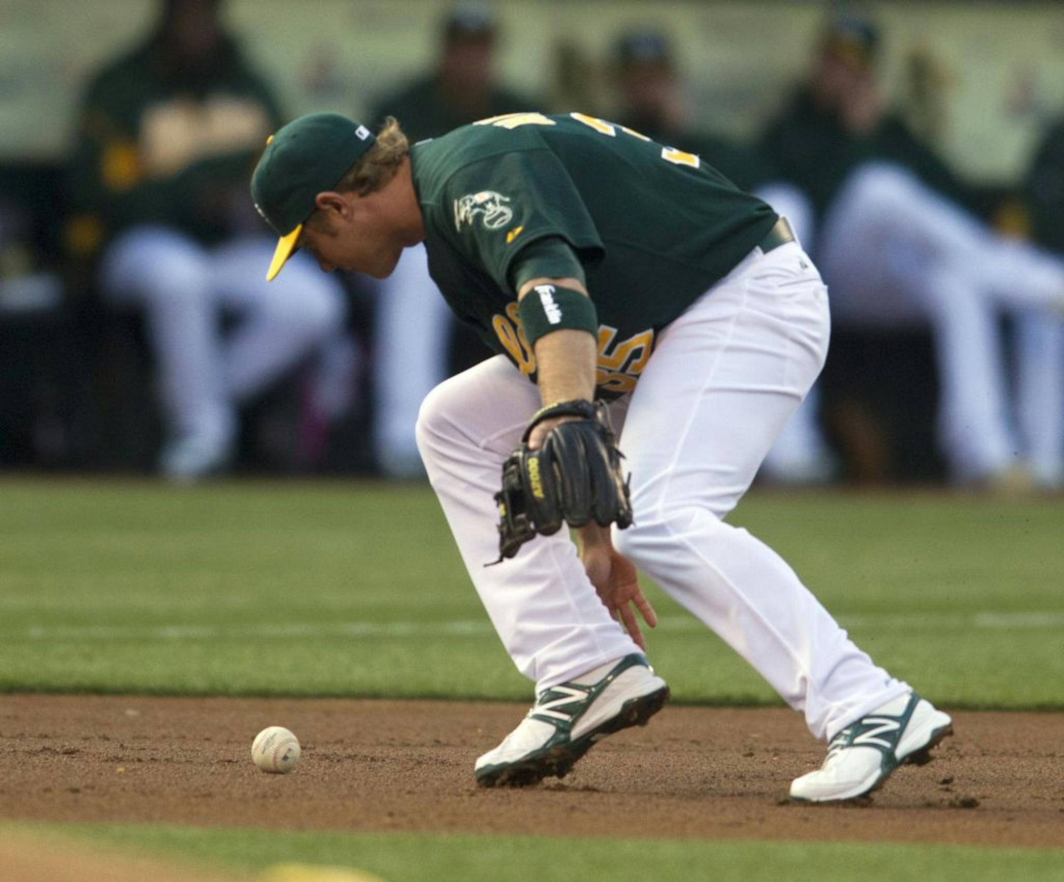 Oakland Athletics third baseman Luke Hughes misplays a ground ball hiti by the Chicago White Sox's Alex Rios in the first inning at O.co Coliseum in Oakland, California, Tuesday, April 24, 2012.