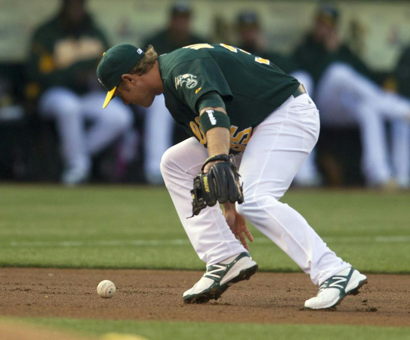 Oakland Athletics third baseman Luke Hughes misplays a ground ball hiti by the Chicago White Sox's Alex Rios in the first inning at O.co Coliseum in Oakland, California, Tuesday, April 24, 2012.