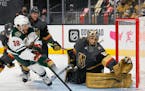 Vegas Golden Knights goaltender Marc-Andre Fleury (29) tries to take the post away from the Minnesota Wild's Ryan Hartman (38) in the first period in 