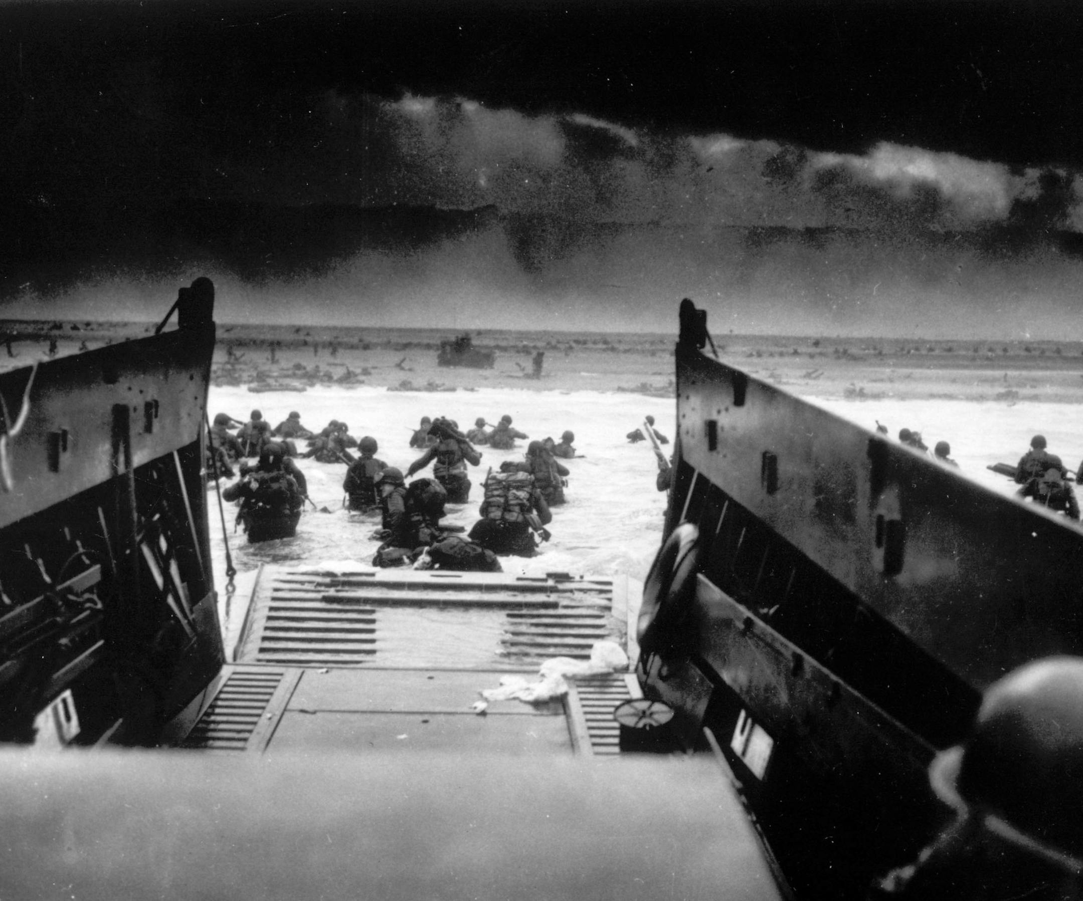 **FOR USE AS DESIRED WITH D-DAY ANNIVERSARY STORIES** FILE** While under attack of heavy machine gun fire from the German coastal defense forces, American soldiers wade ashore off the ramp of a U.S. Coast Guard landing craft in this June 6, 1944 file photo, during the Allied landing operations at Normandy. (AP Photo, File)