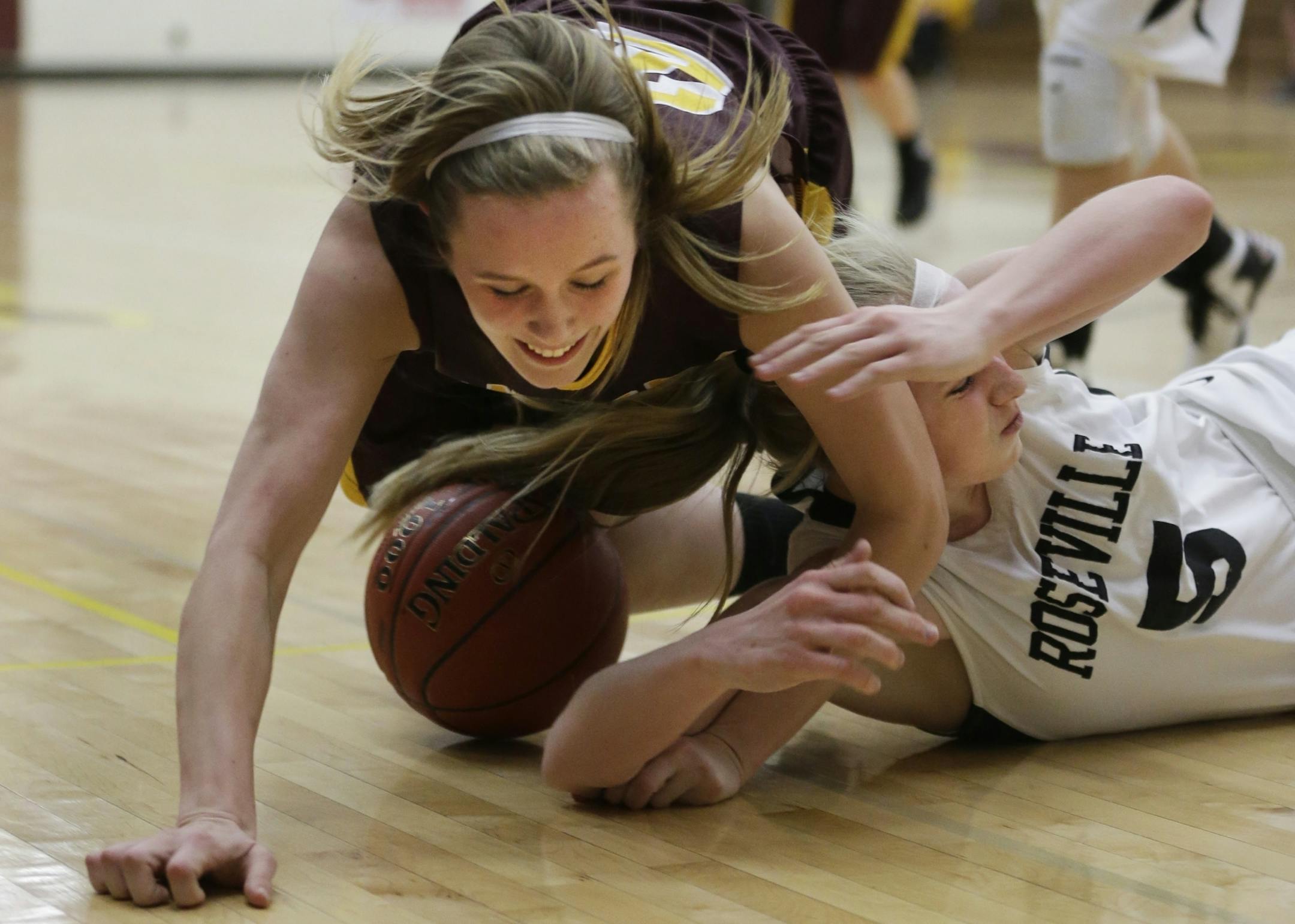 Forest Lake's Abby Moeller dives for a loose ball against Maria Ascher of Roseville.