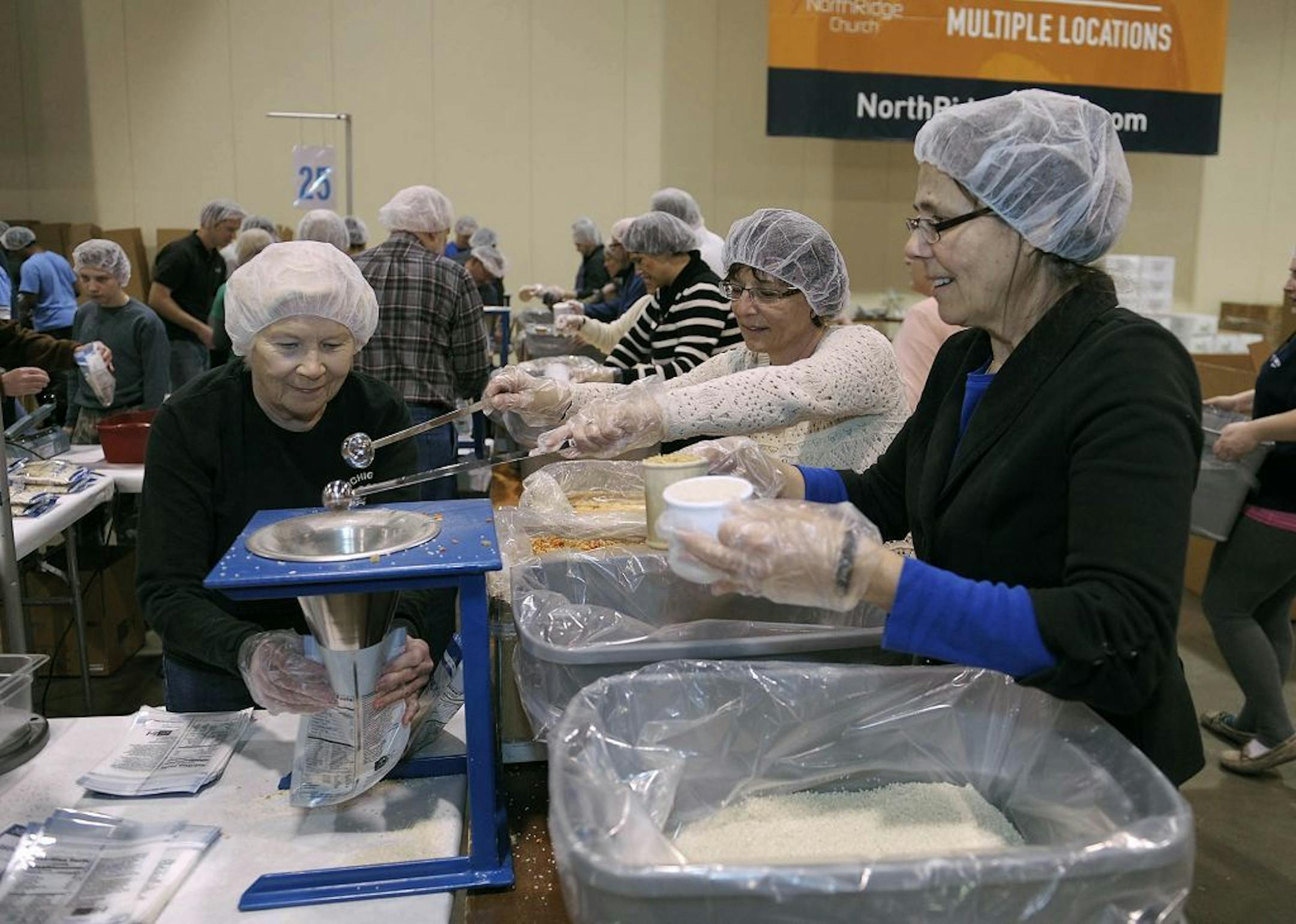 In this Feb. 14, 2014 photo, from left to right, Judy Deckert, Luisa Solak and Jan Bartee, all members of NorthRidge Church, pack whole grain rice, as volunteers pack food for the malnourished during the 2 Million Meals event, in Novi, Mich.