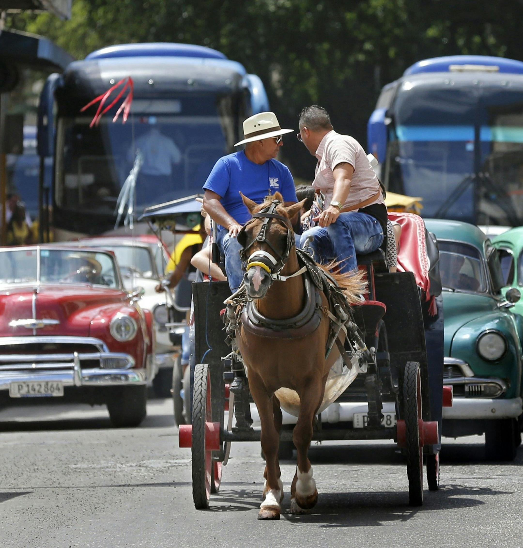 Tourist buses share the road along with vintage American cars and a horse drawn buggy in Havana, Cuba, in March 2016. (Al Diaz/Miami Herald/TNS)