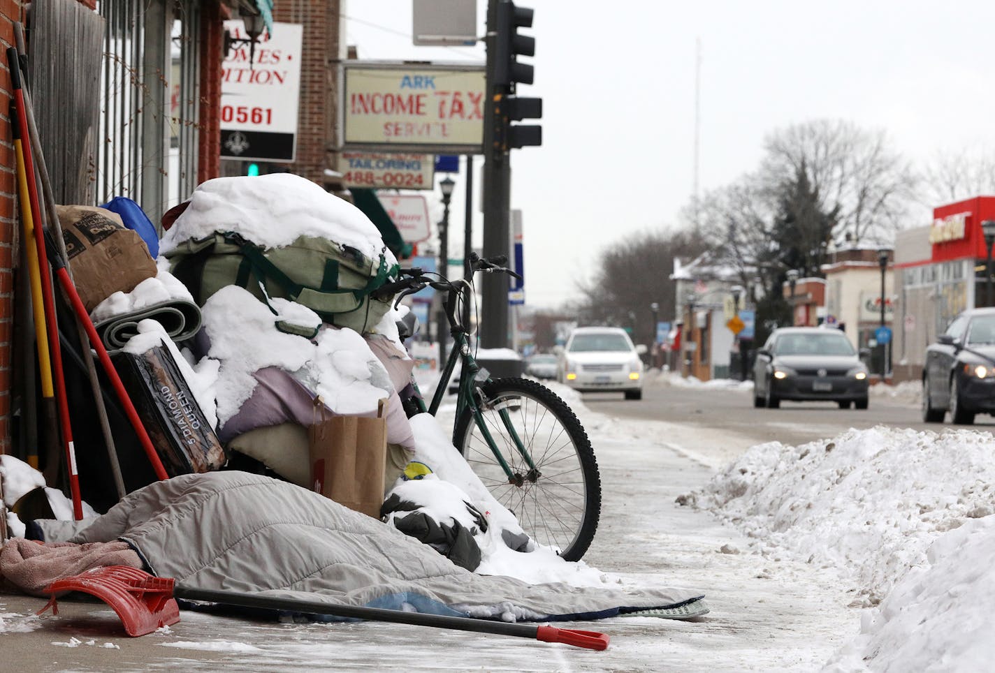 A homeless person slept under a blanket in single digit temperatures along Rice Street Friday. ] ANTHONY SOUFFLE &#x2022; anthony.souffle@startribune.com Scenes from The North End along Rice Street considered is drive-through country to many Friday, Jan. 13, 2017 in St. Paul, Minn.