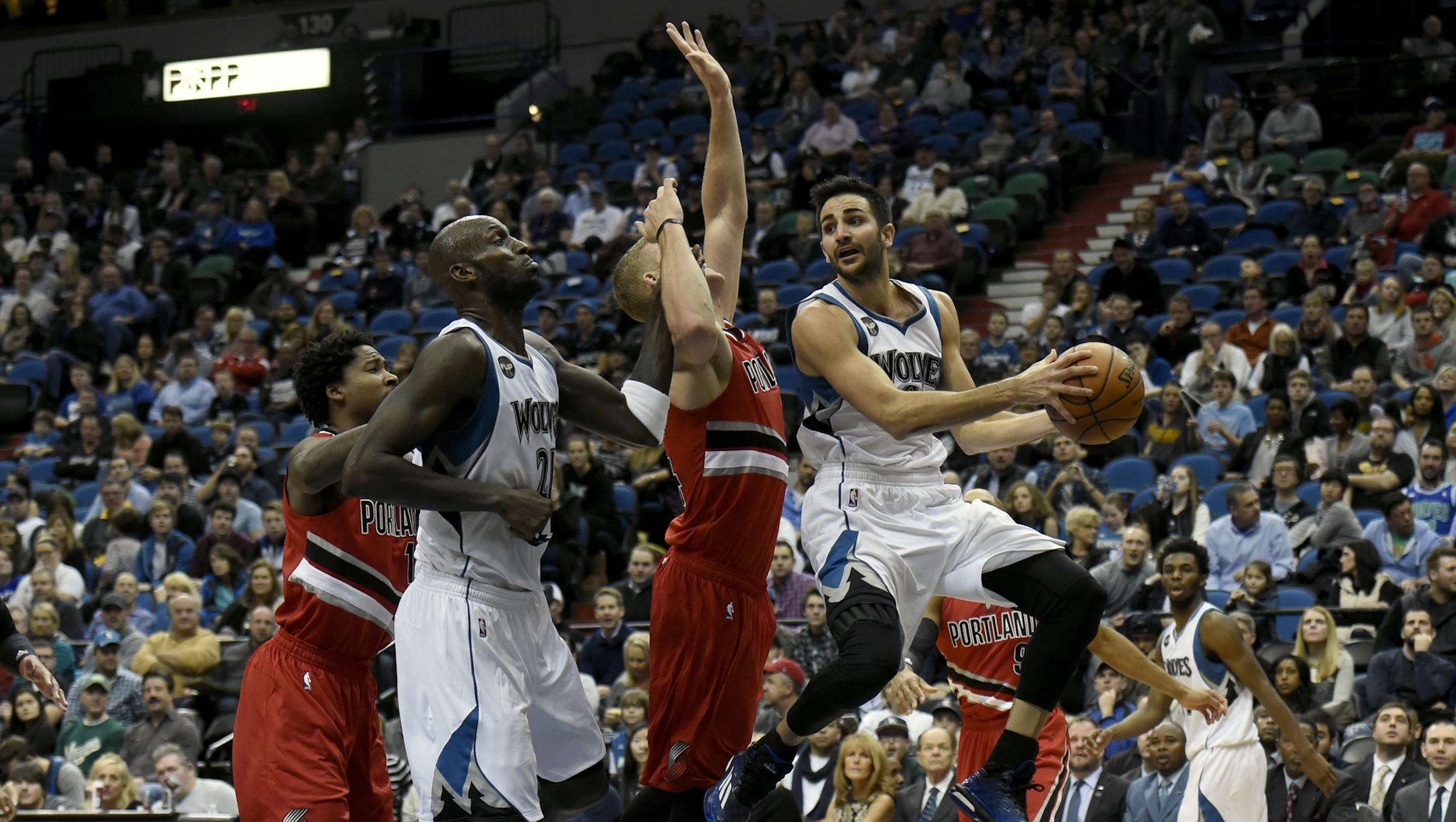Minnesota Timberwolves guard Ricky Rubio, right, of Spain, passes away from Portland Trail Blazers center Mason Plumlee (24) with help from Timberwolves forward Kevin Garnett (21) as Trail Blazers center Ed Davis (17) watches during the second quarter of an NBA basketball game on Saturday, Dec. 5, 2015, in Minneapolis. (AP Photo/Hannah Foslien)