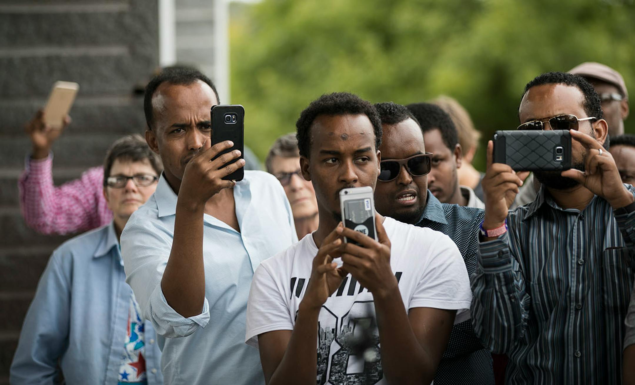 St. Cloud community members record a press conference with their phones.