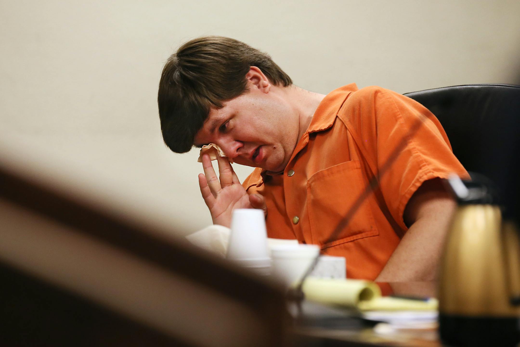 Justin Ross Harris, the father of a toddler who died after police say he was left in a hot car for about seven hours, wipes his eye as he sits during his bond hearing in Cobb County Magistrate Court, Thursday, July 3, 2014, in Marietta, Ga. Harris who police say intentionally killed his toddler son by leaving the boy inside a hot SUV was exchanging nude photos with women the day his son died and had looked at websites that advocated against having children, a detective testified Thursday. At tha
