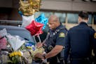 St. Paul Police Officer Anthony Buckley placed a badge on a police vehicle that has become one of three memorials in front of the Burnsville Police De