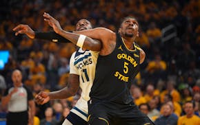 Timberwolves’s Naz Reid and Golden State Warriors’s Kevon Looney get tangled up while waiting for a possible Timberwolves free throw rebound in th