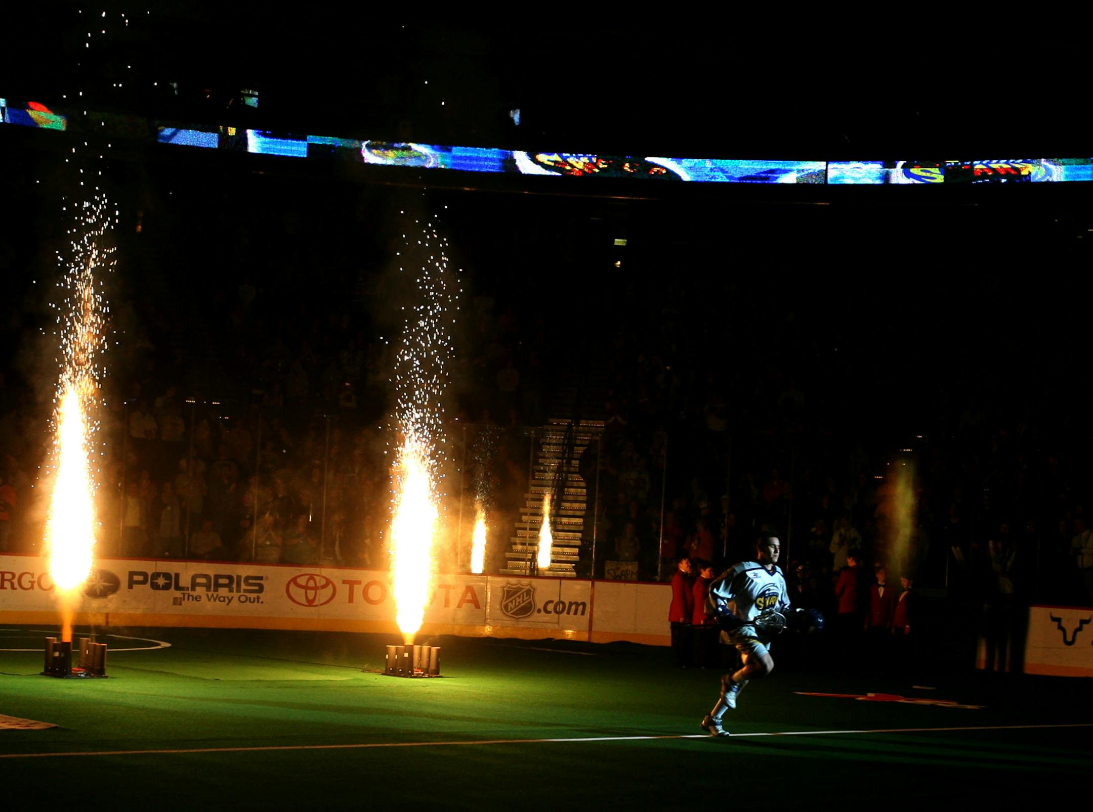 A Minnesota Swarm player bathed in the glow of pyrotechnics during introductions before the start of a 2008 game at Xcel Energy Center. The Swarm is trying to increase its season-ticket base to address financial losses.