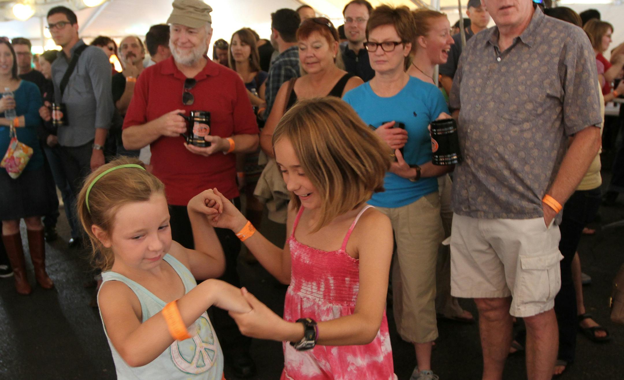 (left to right) Ava Bednarz, age-9 and Eleanor Allen, age-9, both of Minneapolis made their own music as they danced before the Cheremosh! Ukrainian Folk Dance Ensemble from N.E. Minneapolis took the stage during the Kramarczuk Sausage Company's Kielbasa Festival in N.E. Minneapolis on 9/8/12. The dance group features over sixty dancers from age 4 to 23. All-day fest featured live music, dancers, a potato pyrohy eating contest and lots of sausages and beer.] Bruce Bisping/Star Tribune bbisping@s