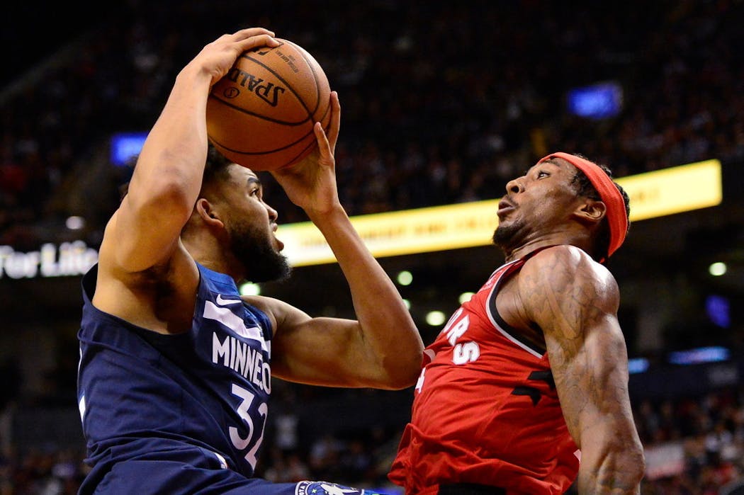 Karl-Anthony Towns (32) drives at Toronto Raptors forward Rondae Hollis-Jefferson (4) during the second half.
