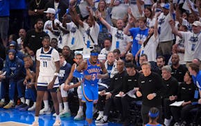 Oklahoma City Thunder guard Luguentz Dort (5) celebrates a three-pointer as Timberwolves center Naz Reid (11) looks on in the fourth quarter.