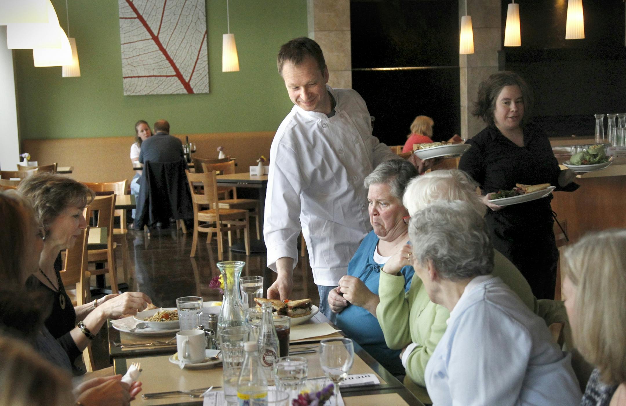 Chef-owner Robert Ulrich helps serve lunch to a table at his Mendota Heights restaurant, Mendoberri.