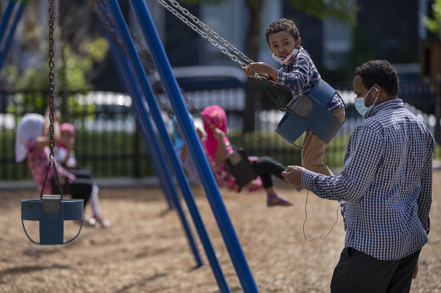 Kadir Dhekama 37, played with his son Dawwee Dhekama 5, on a swing set in Currie Park. Kadir who ives in the Cedar Riverside area said that he has completed his census forms .] Jerry Holt •Jerry.Holt@startribune.com A press conference was held at the Brian Coyle center ,where census advocates, including the state demographer, discussed their concerns that the Census bureau is wrapping up field operations too quickly in Hennepin County Monday August 31,2020 in Minneapolis. ,MN.