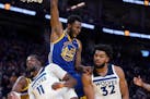 Golden State Warriors forward Andrew Wiggins (22) reacts after dunking against Minnesota Timberwolves’ Naz Reid (11) and Karl-Anthony Towns (32) on 