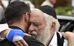 Rabbi Yisroel Goldstein, right, is hugged as he leaves a news conference at the Chabad of Poway synagogue, Sunday, April 28, 2019, in Poway, Calif. A 