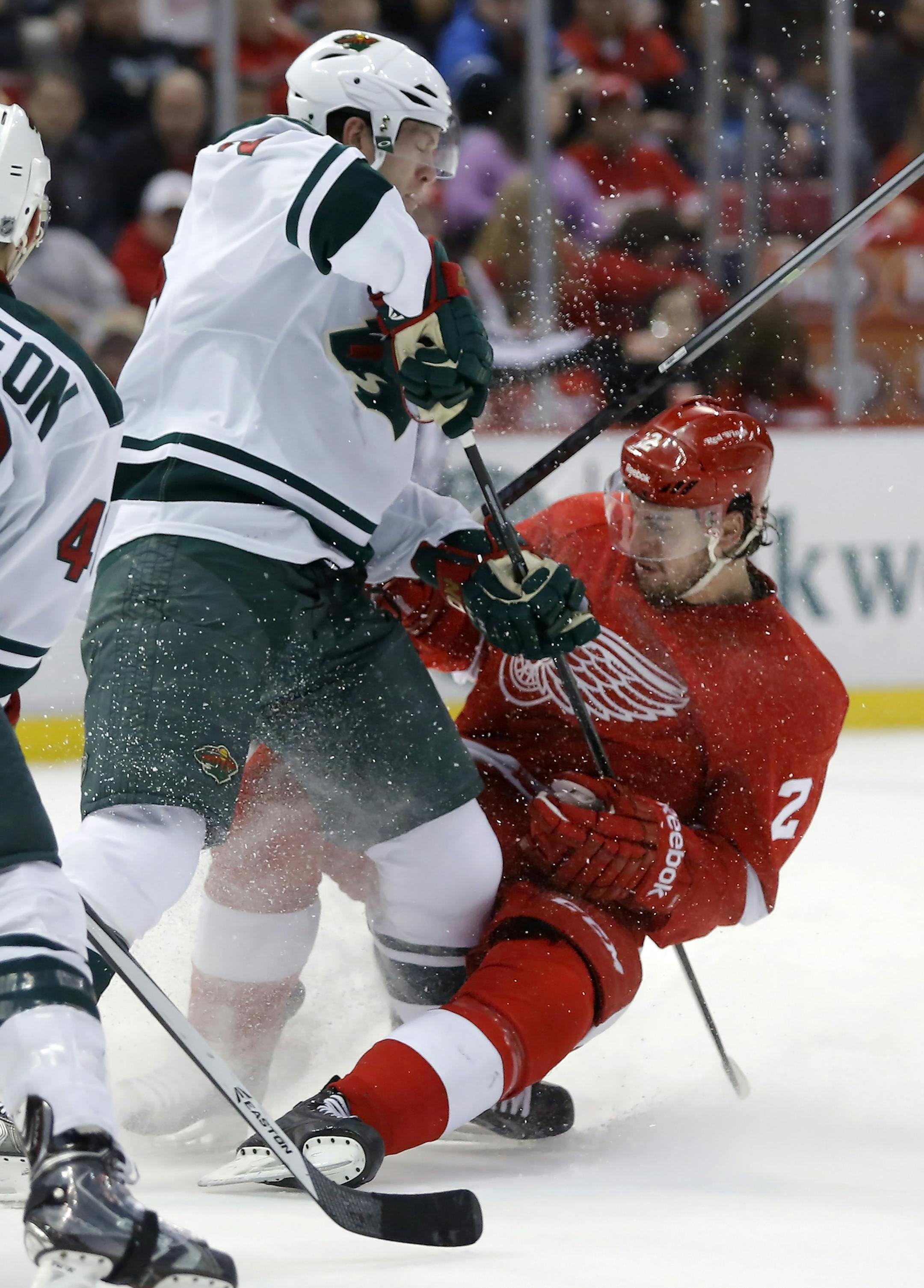 Minnesota Wilds' Ryan Suter, left, knocks Detroit Red Wings' Brendan Smith (2) off the puck during the second period of an NHL hockey game Sunday, March 23, 2014 in Detroit. (AP Photo/Duane Burleson)