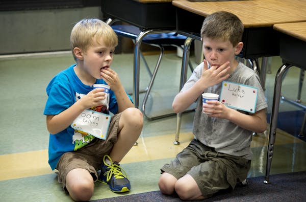 First graders Sam Collins and Luke Holter sucked on ice cubes in their un air conditioned classroom at Hiawatha Elementary School in Minneapolis on Mo