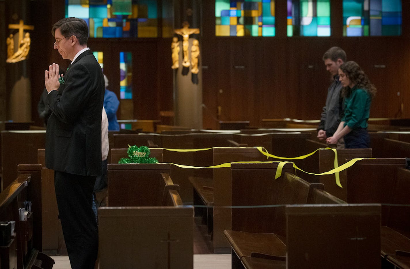 St. Olaf Catholic Church parishioner and volunteer Eric Nelson, left, celebrated a St. Patrick's Mass with few parishioners that were separated by tape and ribbons to distance from each other, Tuesday, March 17, 2020 in Minneapolis.