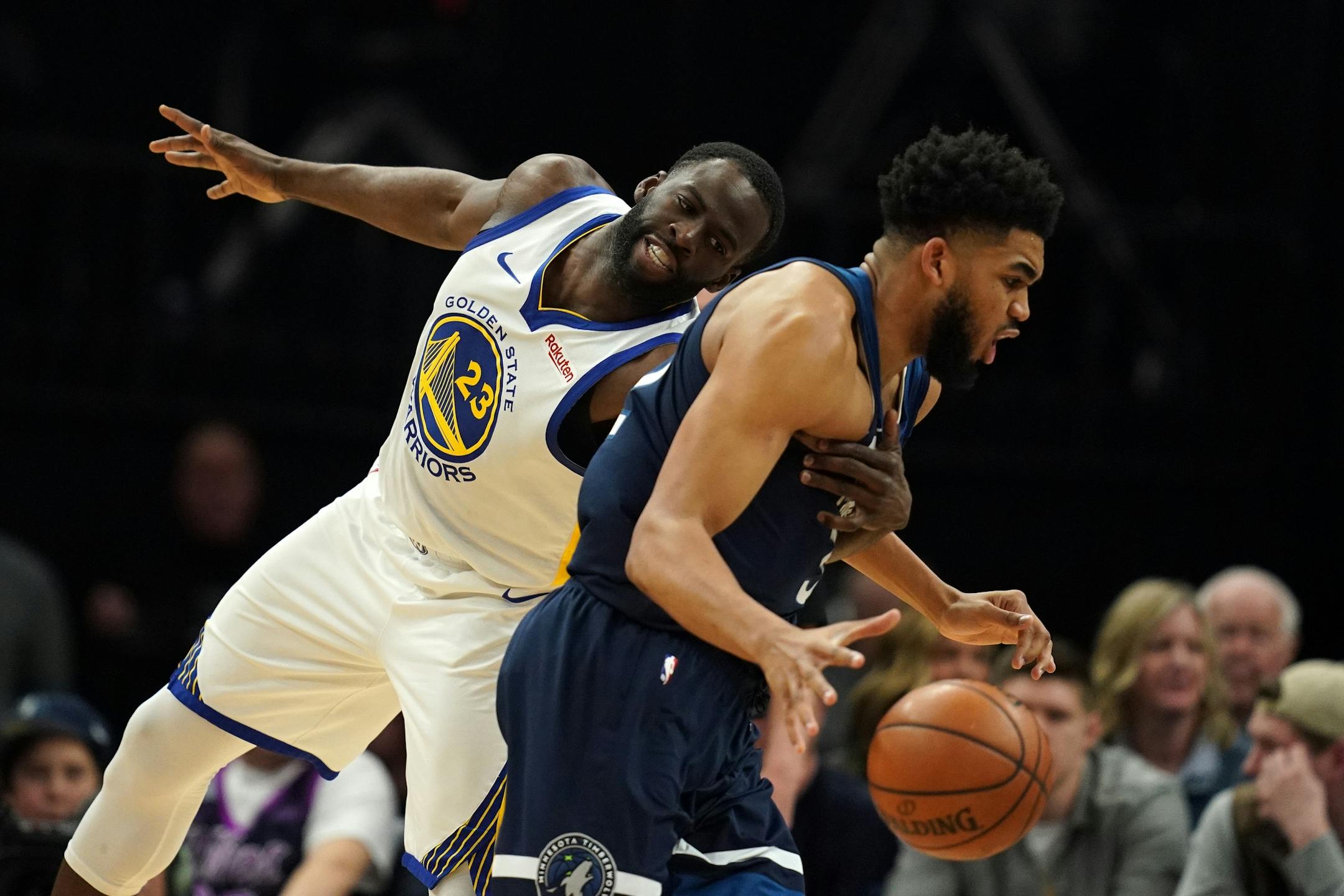Golden State Warriors forward Draymond Green (23) grabbed Minnesota Timberwolves center Karl-Anthony Towns (32) as he drove to the basket in overtime.