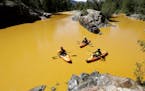 FILE - In this Thursday, Aug. 6, 2015 file photo, people kayak in the Animas River near Durango, Colo., in water colored yellow from a mine waste spil