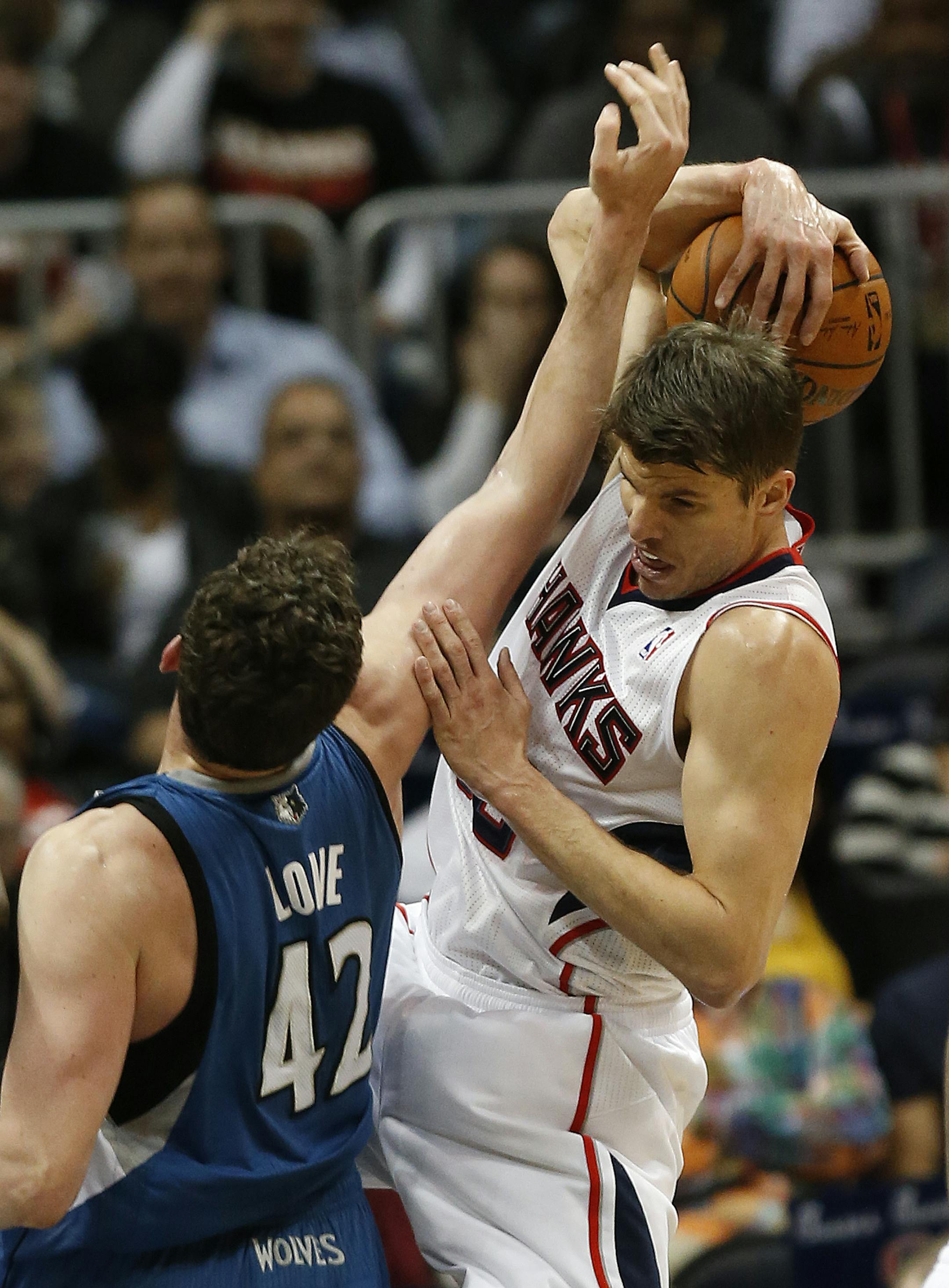 Atlanta Hawks shooting guard Kyle Korver (26) grabs a rebound against Minnesota Timberwolves forward Kevin Love (42) in the first half of an NBA basketball game, Saturday, Feb. 1, 2014, in Atlanta. (AP Photo/John Bazemore)