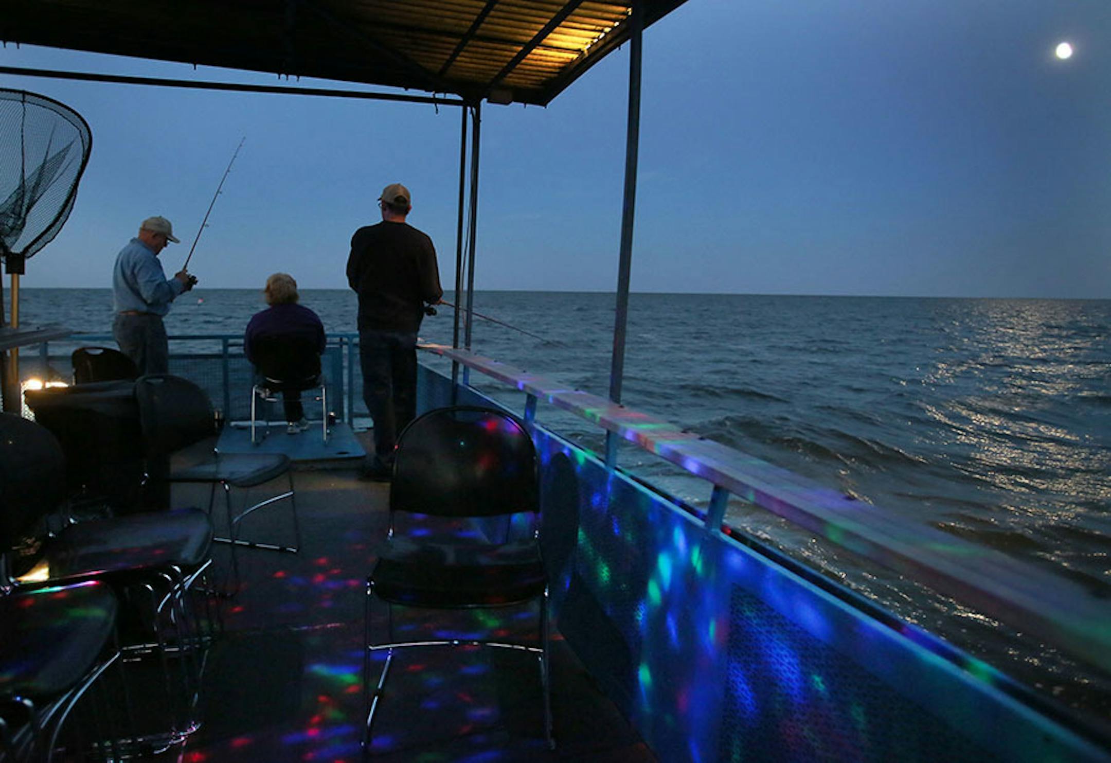 Fishermen on the Twin Pines Resort boat fish by moon light and disco lights Wednesday, July 29, 2015, during an evening excursion on Lake Mille Lacs.