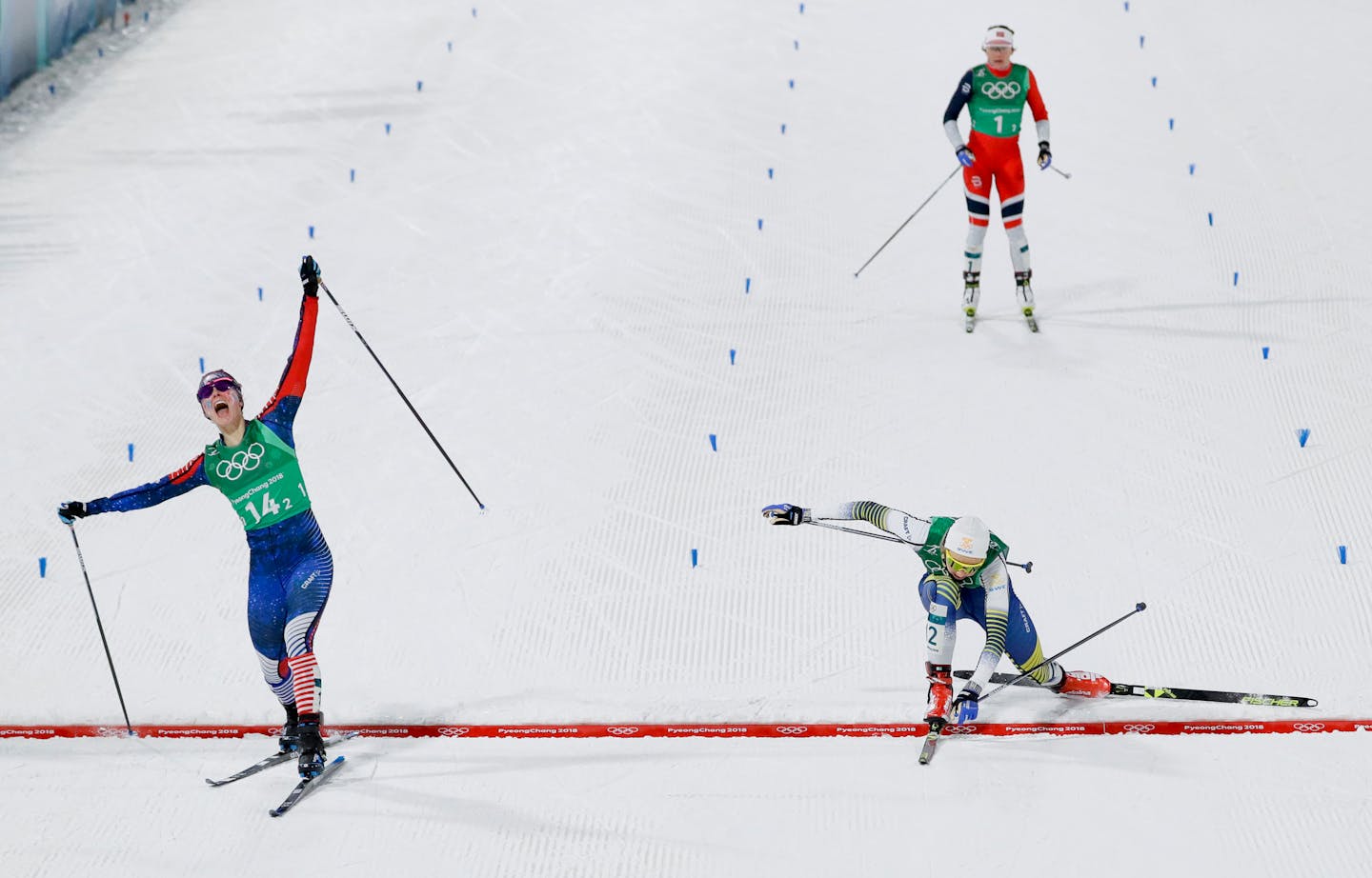 Jessie Diggins, left, of the United States, celebrates after winning the gold medal past Stina Nilsson of Sweden, in the during women's team sprint freestyle cross-country skiing final at the 2018 Winter Olympics.