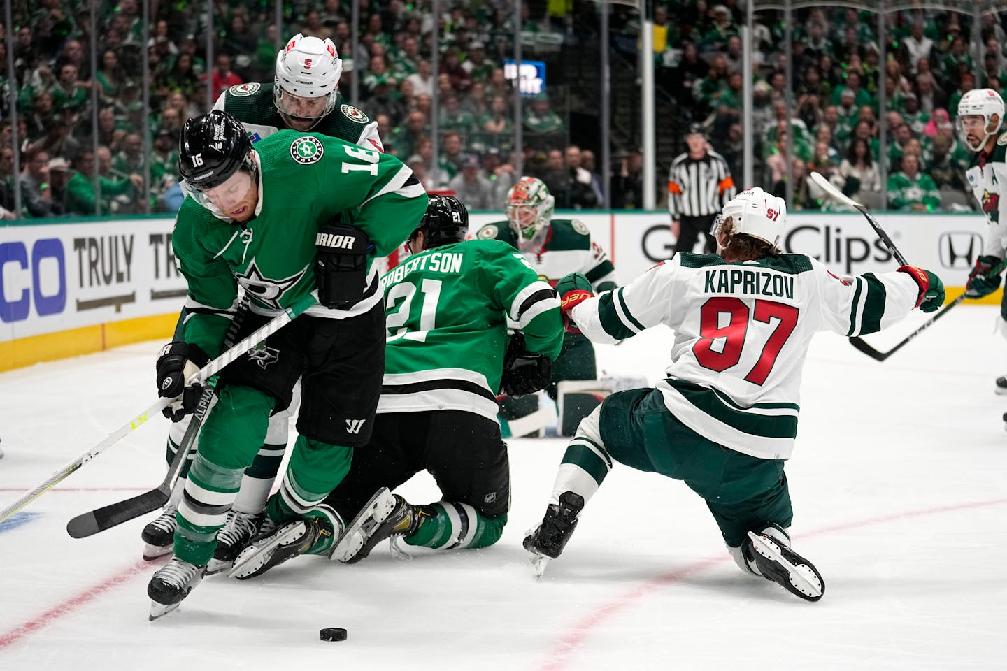 Dallas Stars center Joe Pavelski works to take control of the puck in front of Minnesota Wild defenseman Jake Middleton (5) as Jason Robertson (21) and Kirill Kaprizov (97) collide during play in the first period of Game 1 of an NHL hockey Stanley Cup first-round playoff series, Monday, April 17, 2023, in Dallas. (AP Photo/Tony Gutierrez)