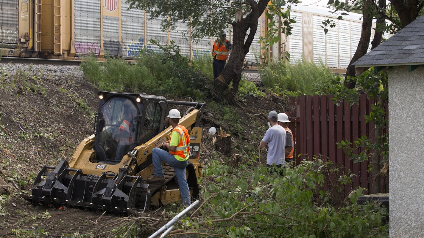 Workers cut trees along the railroad tracks behind homes in the 2300 block of 7th Street N.E. in Minneapolis Thursday afternoon. ] BNSF's plans to expand their railroad capacity is bringing tracks about 14 feet closer to people's homes along a tight corridor in Northeast Minneapolis. Homeowners are upset, in part because BNSF says they actually own the land that contains the yards and garages of private homes. Workers are already tearing down trees that sheilded homeowners from the 95 trains tha