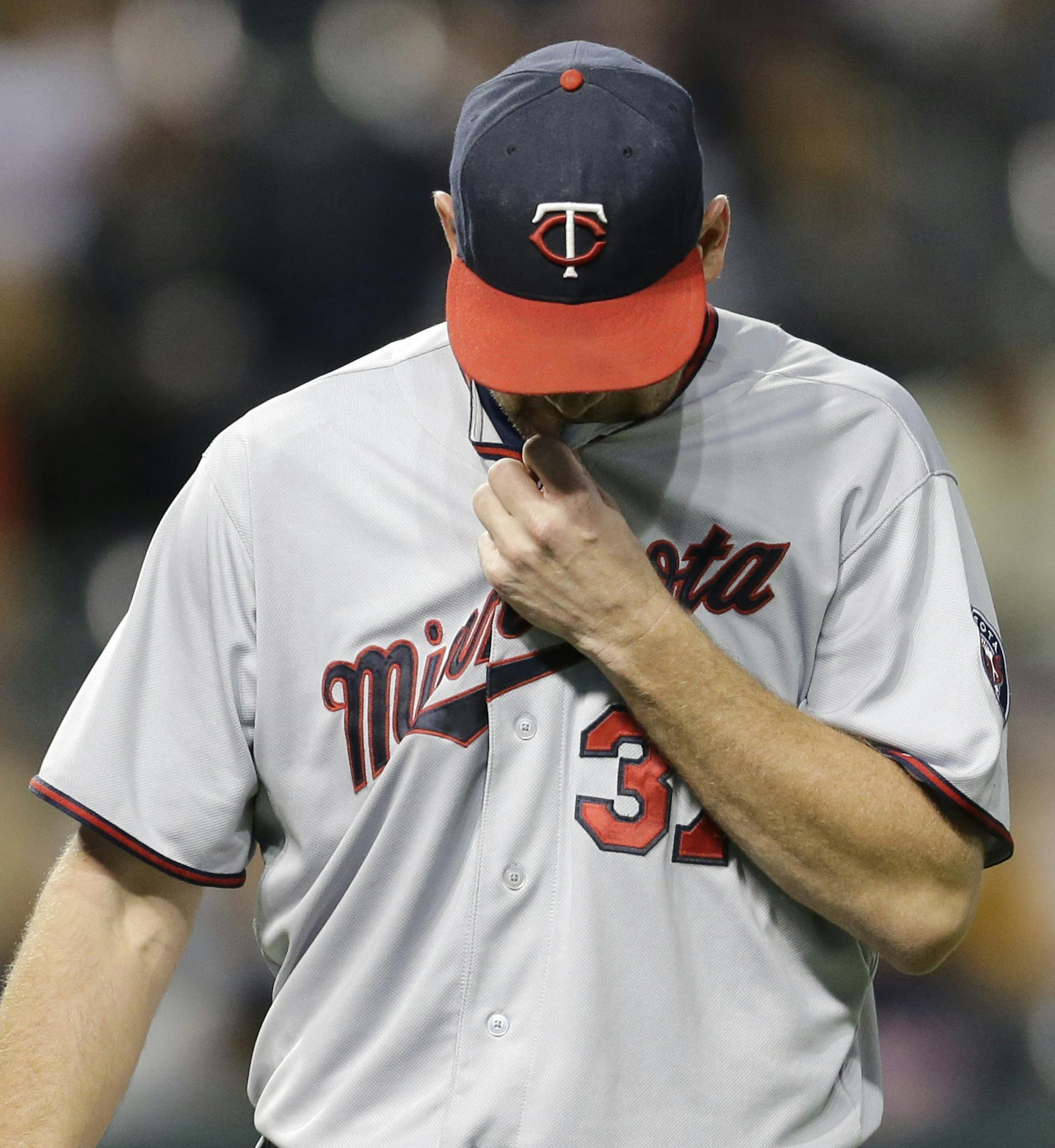 Minnesota Twins starting pitcher Mike Pelfrey walks back to the dugout in the second inning of the second baseball game of a doubleheader against the Cleveland Indians, Wednesday, Sept. 30, 2015, in Cleveland. (AP Photo/Tony Dejak)