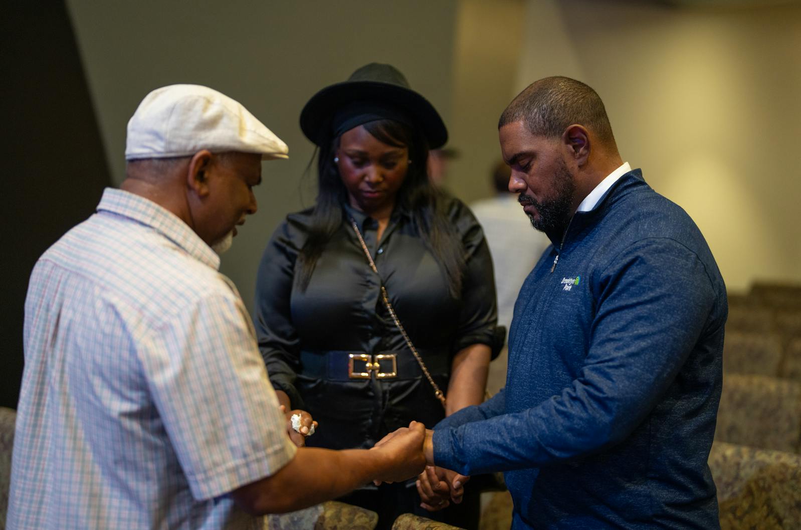 Brooklyn Park Mayor Hollies J. Winston, right, and his wife Latrice Winston, pray with Joy Daniel, left, who lives near the Hortmans, during a community prayer service at Grace Fellowship Church in Brooklyn Park on Monday.