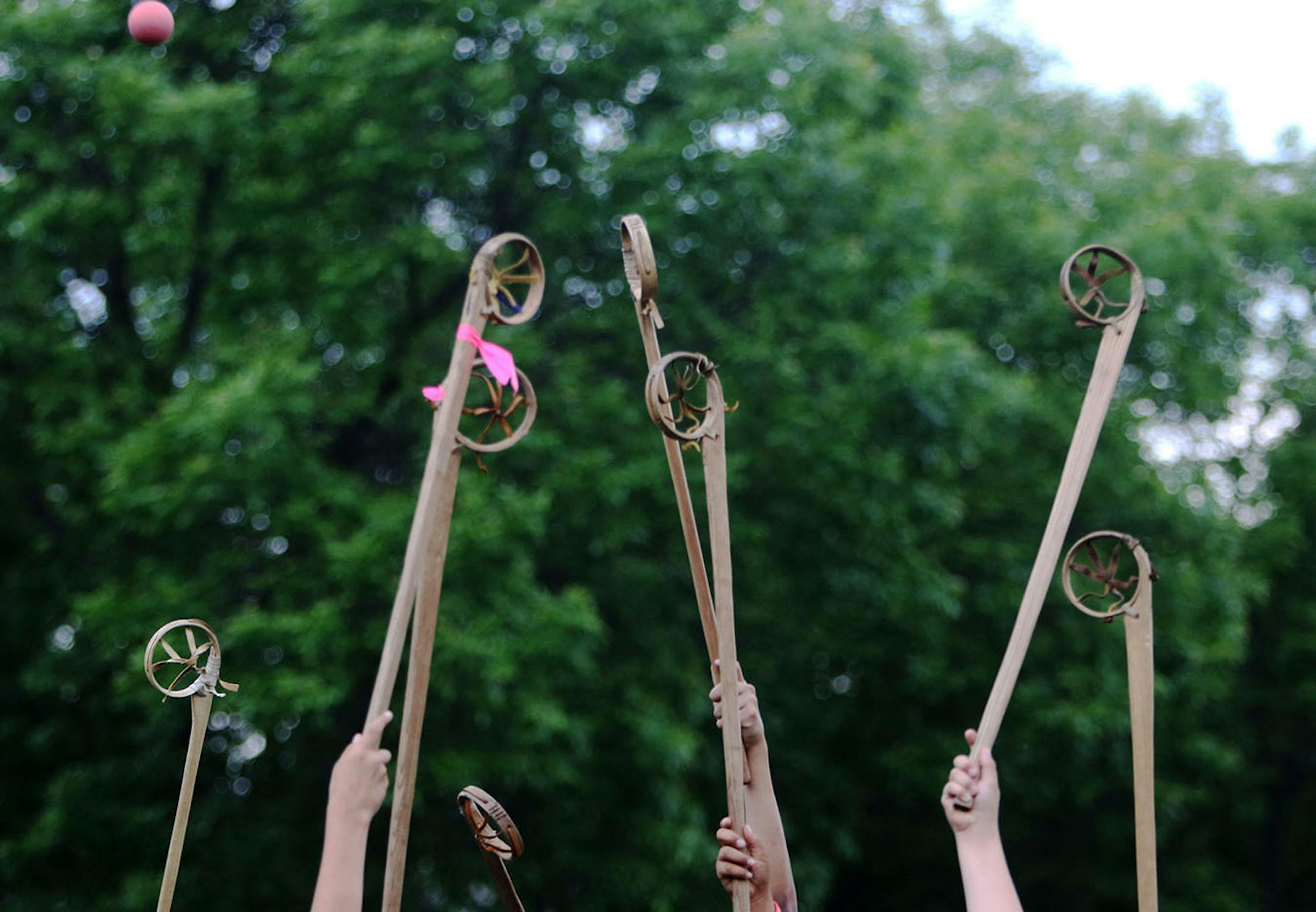 Youth boys team members of Twin Cities Native Lacrosse raise their sticks skyward during the face off during practice at Corcoran Park Wednesday, June 17, 2015, in Minneapolis, MN. The traditional Lacrosse players, who play with hand carved ash sticks, were preparing for the upcoming Twin Cities Native Lacrosse Tournament at the Osseo High School Saturday.